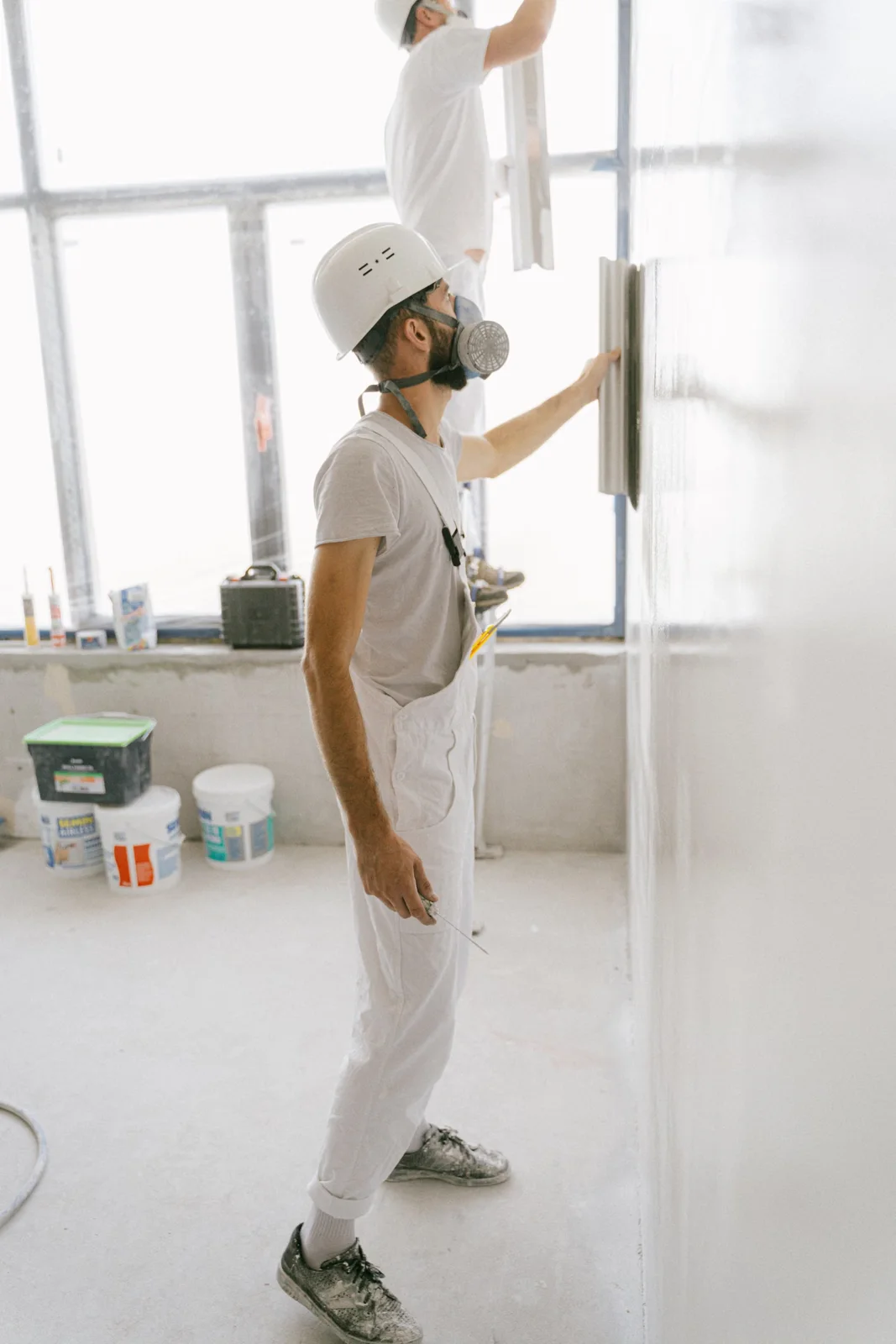 保護具を着用して壁面を整える内装作業のイメージ